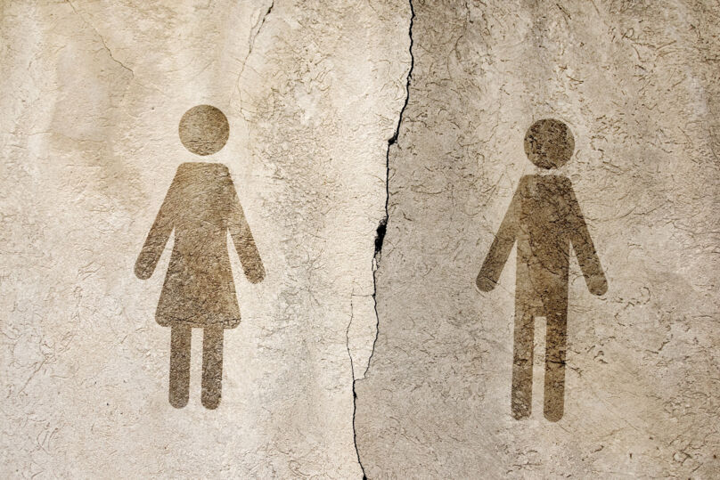Ilustração tem dois bonecos, um feminino e outro masculino, na cor marrom. Eles estão sobre uma superfície bege com rachaduras. Há uma rachadura maior, que  "separa" o casal de bonecos.