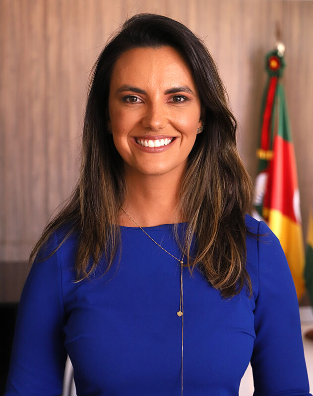 Foto da juíza do Trabalho Carolina Gralha. Ela é morena, de cabelos lisos e longos e usa uma blusa azul.