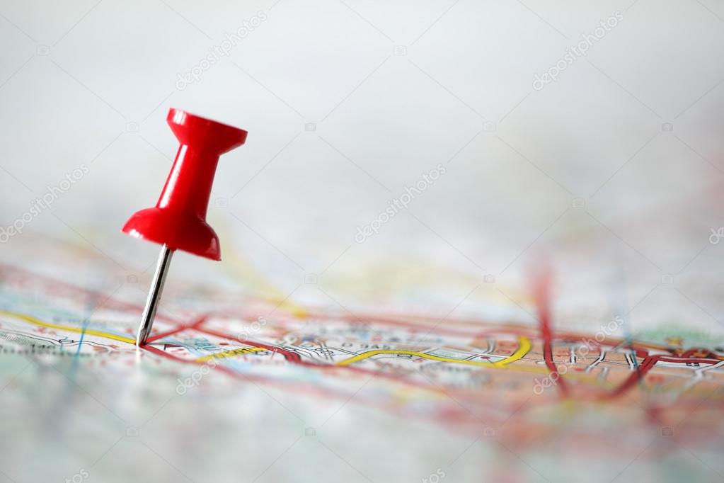 Foto de um alfinete vermelho posicionado sobre um mapa, passando a ideia de localização.