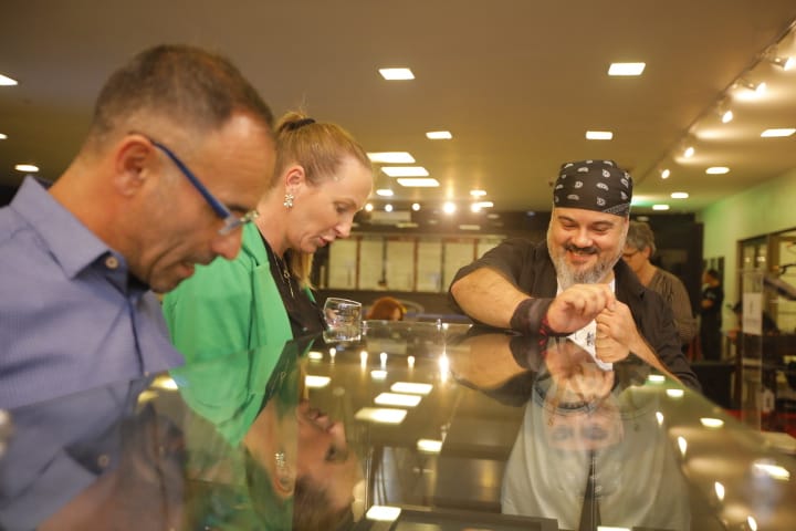 Foto do artista Alesxandro Rogério conversando com o público na mostra "Conexão Poa".