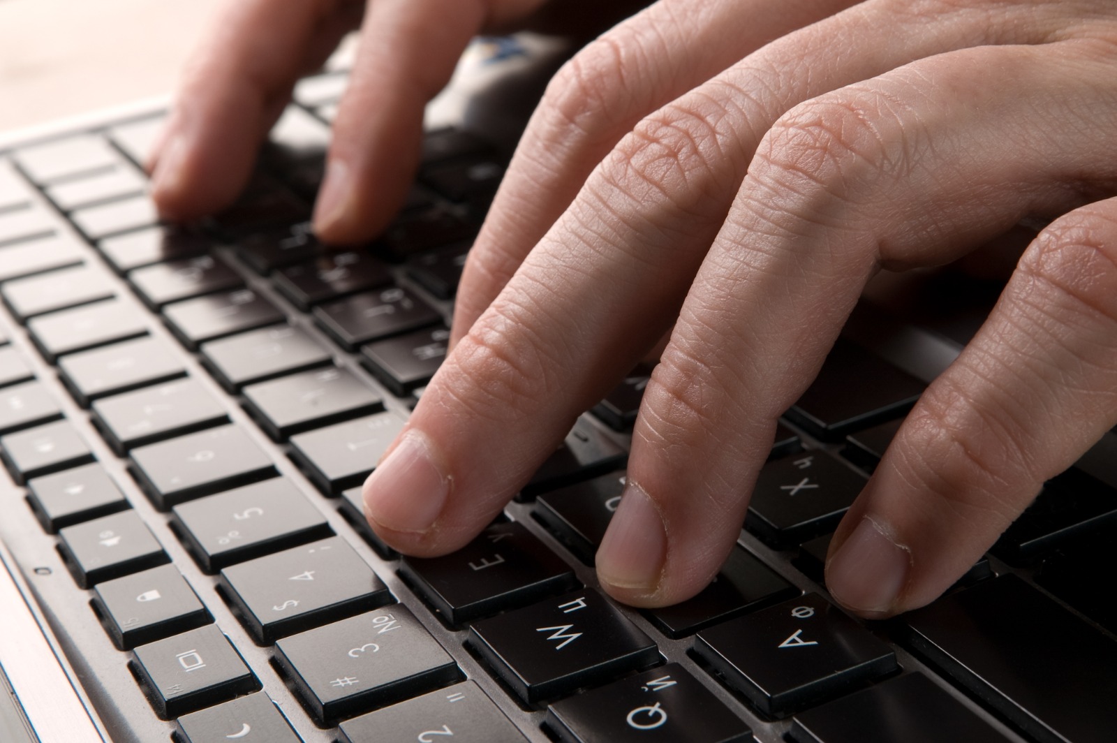 Imagem ilustrativa mostra as mãos de um homem digitando um teclado de computador