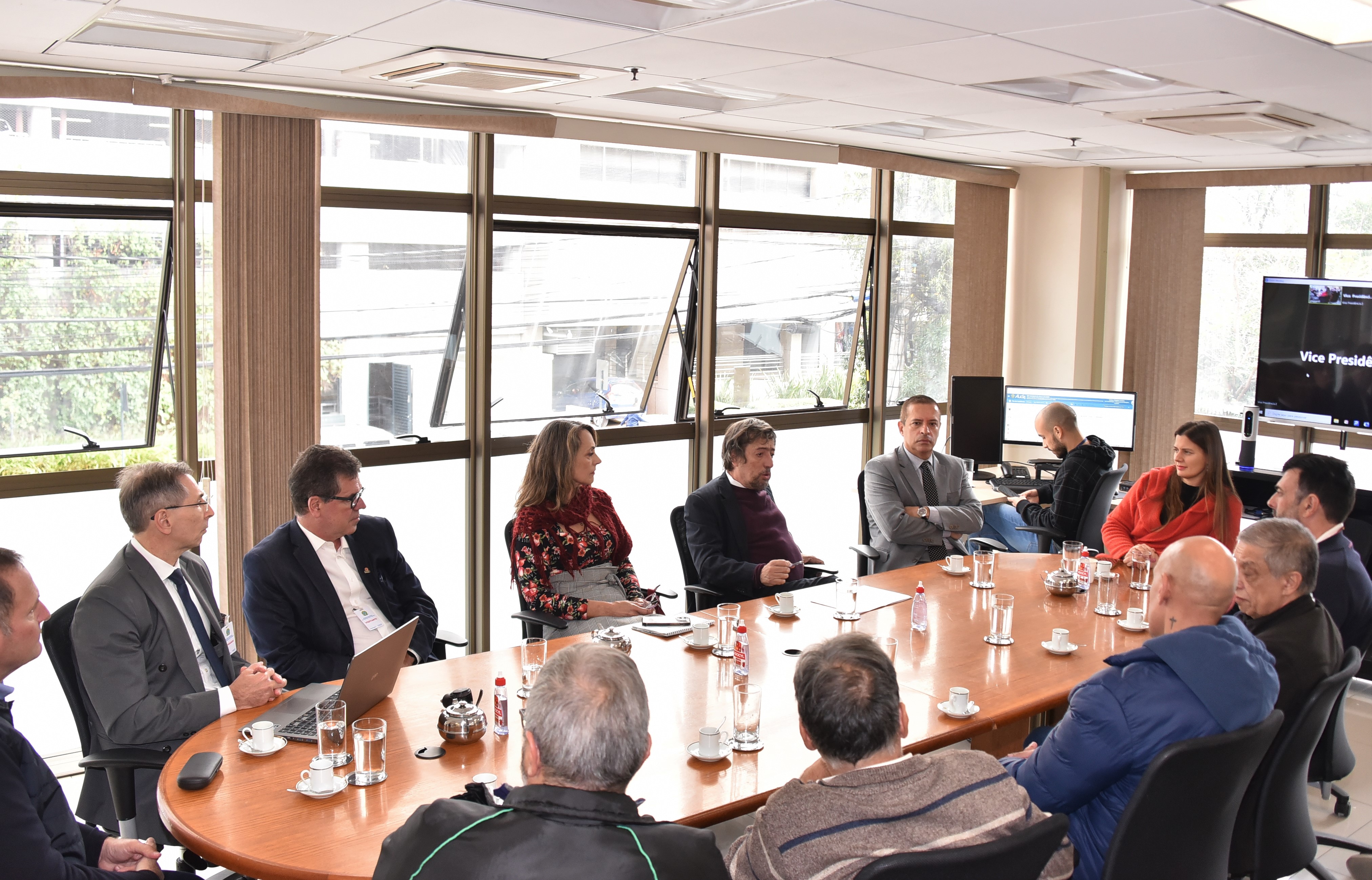Foto da reunião de mediação. Participantes estão sentados em volta de uma mesa.