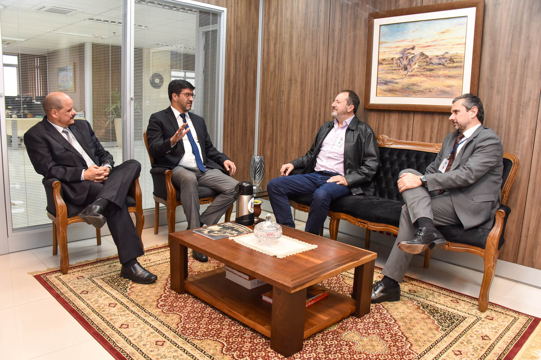 Foto da reunião no gabinete. A imagem mostra sentados, da esquerda para a direita, Daniel Nonohay, Francisco Rossal, Claudir Nespolo e Adolfo Marques Pereira.