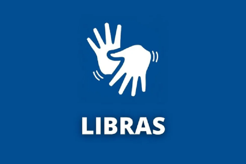 Fundo azul com o símbolo da Língua Brasileira de Sinais na cor branca (ícone de duas mãos abertas, sendo uma na frente da outra. Uma está com os dedos apontados para cima e outra apontados para baixo). Abaixo está escrito "LIBRAS" em cor branca.