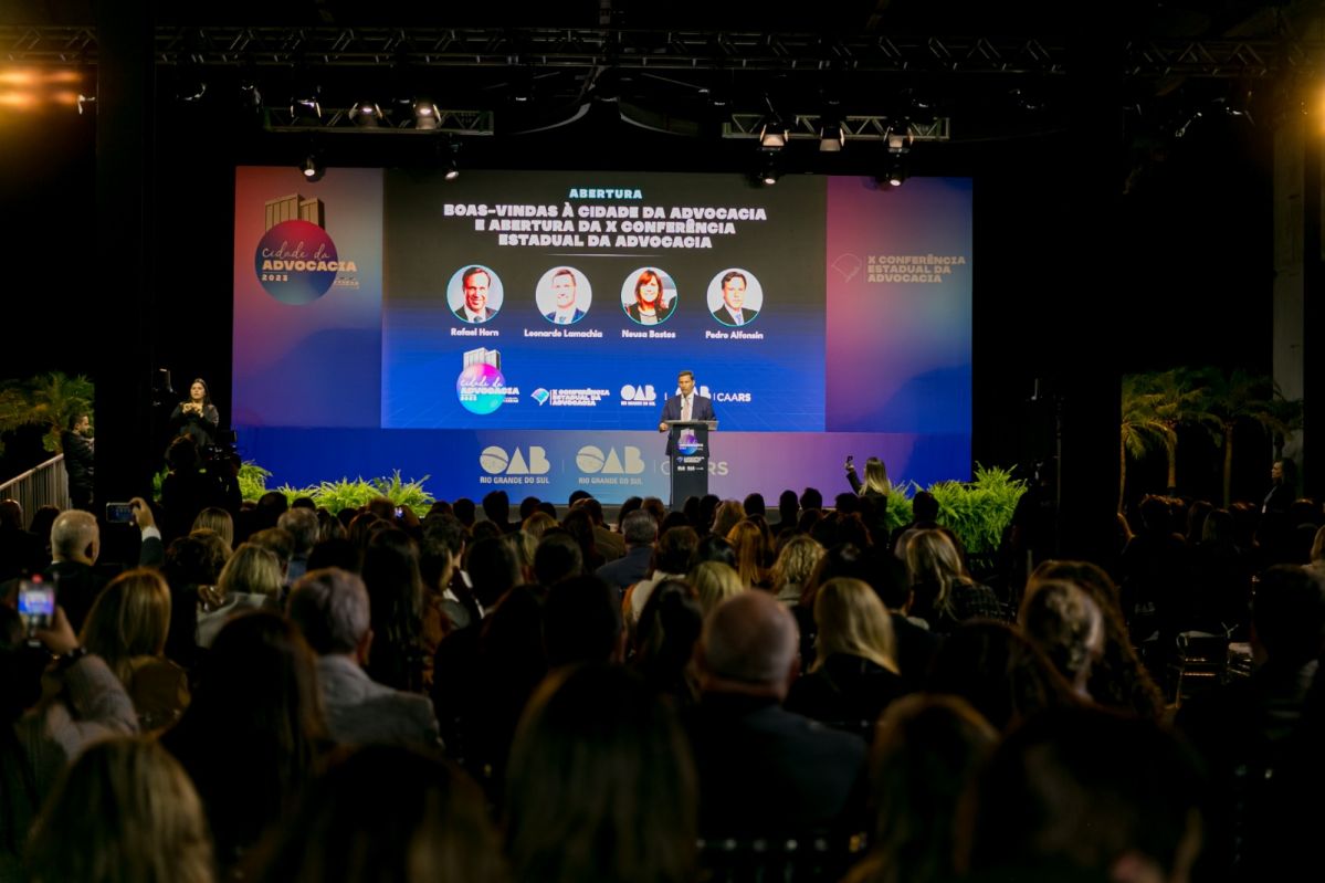 Foto do evento, mostrando palco e público, durante fala do presidente da OAB, Leonardo  Lamacha.