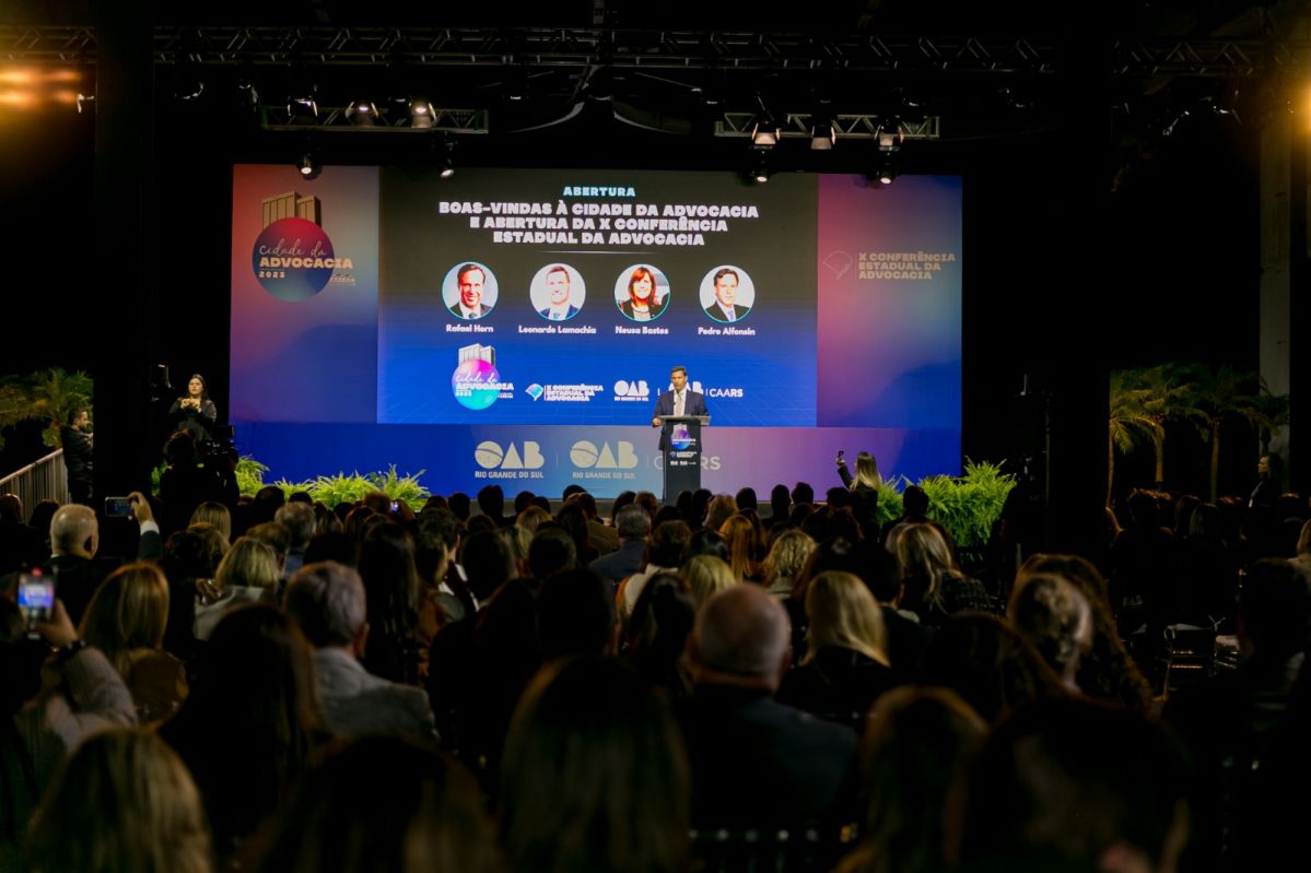 Foto do evento, mostrando palco e público, durante fala do presidente da OAB, Leonardo Lamacha.