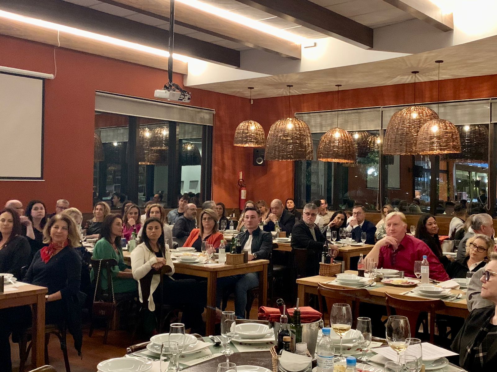 Foto de participantes da celebração dos 30 anos da 3ª VT de Caxias do Sul sentados em mesa no restaurante.