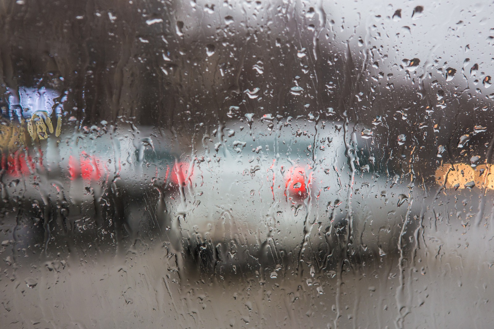 Foto ilustrativa da chuva vista pelo parabrisa de um automóvel