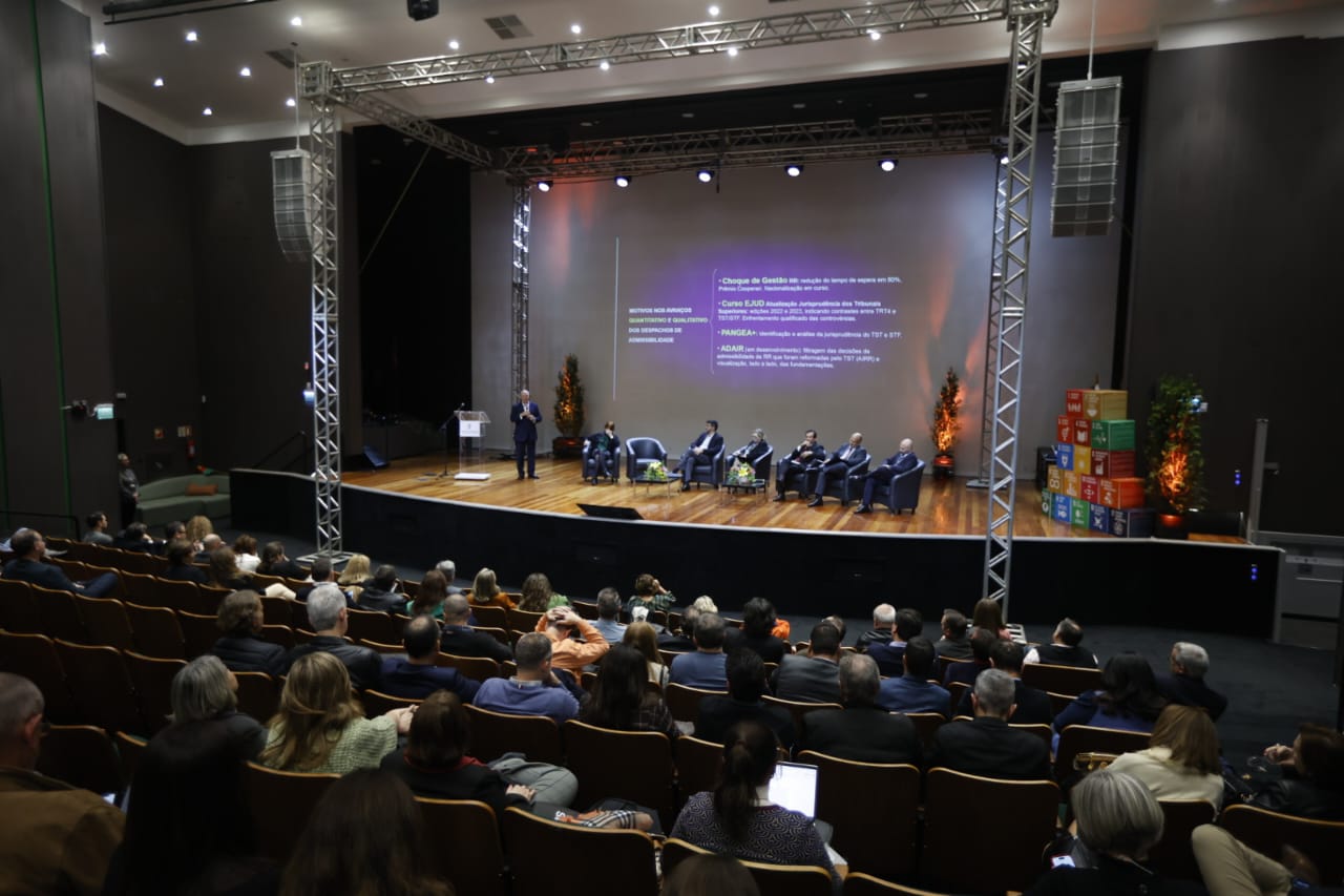 Foto em ângulo aberto, mostrando público e palco