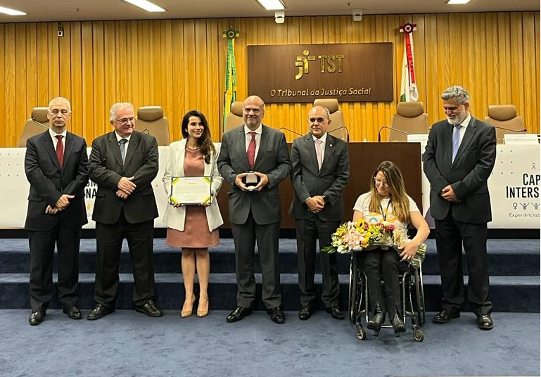 Foto posada na entrega do prêmio, aparecendo os ministros Augusto, Mauricio, Cláudio e Lelio, o desembargador Lucena, a juíza Carolina e a assessora Ekaterini.