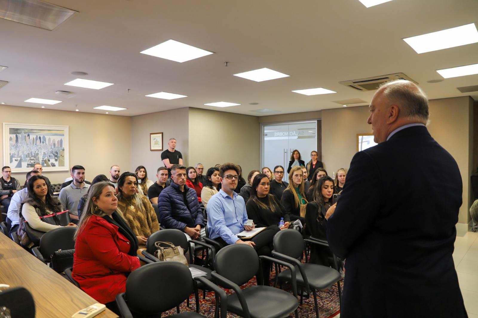 Foto dr Ricardo de costas pra foto conversando com estudantes.jfif