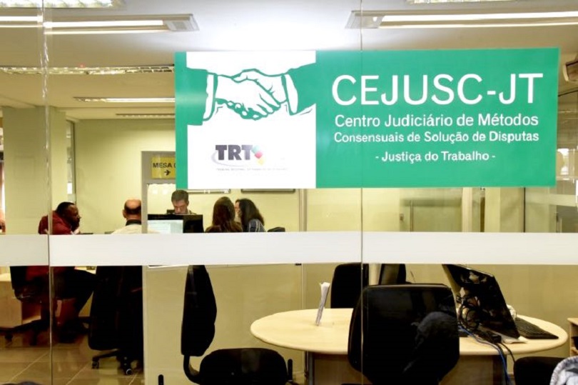 Sala do Cejusc na qual partes e conciliadores estão realizando audiência.