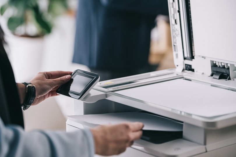 Homem digitaliza documento em impressora multifuncional