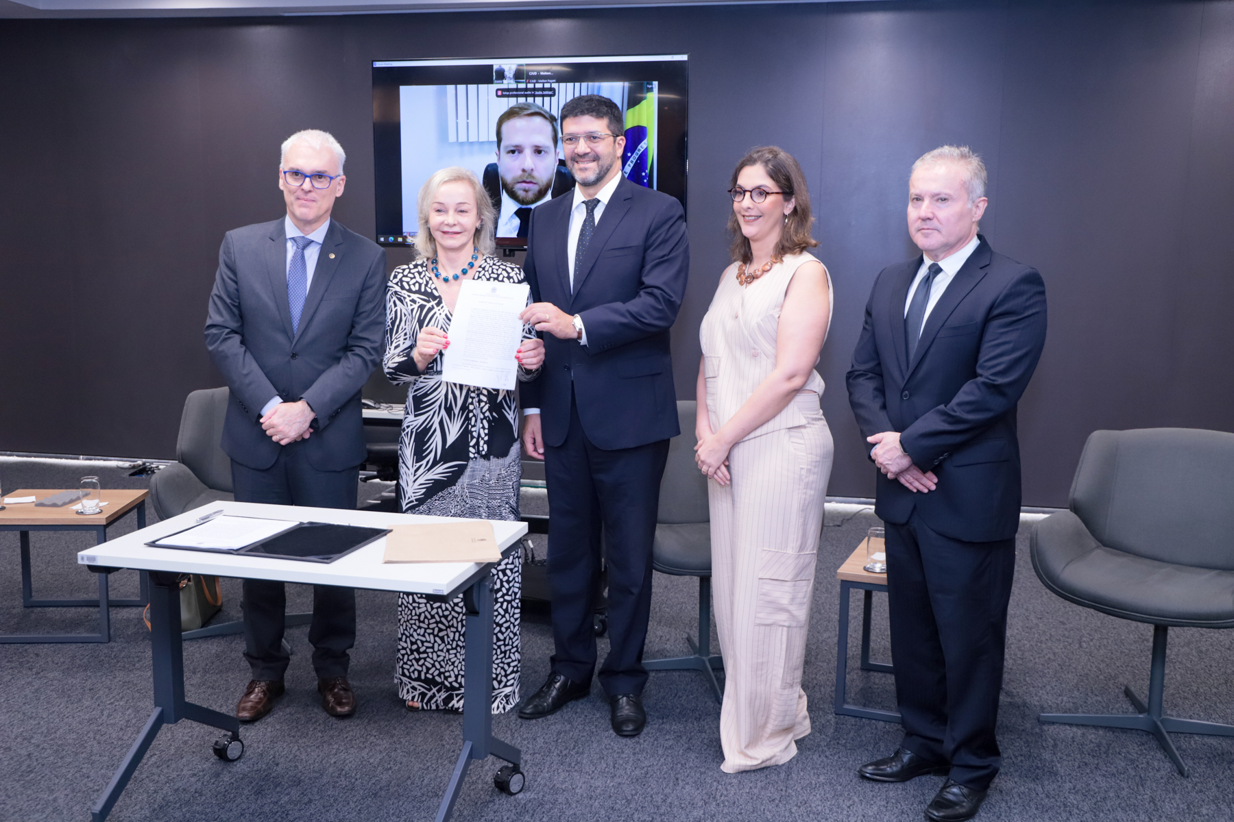 Foto dos representantes das cinco instituições signatárias, em pé, com o ofício nas mãos da presidente do TRE-RS.