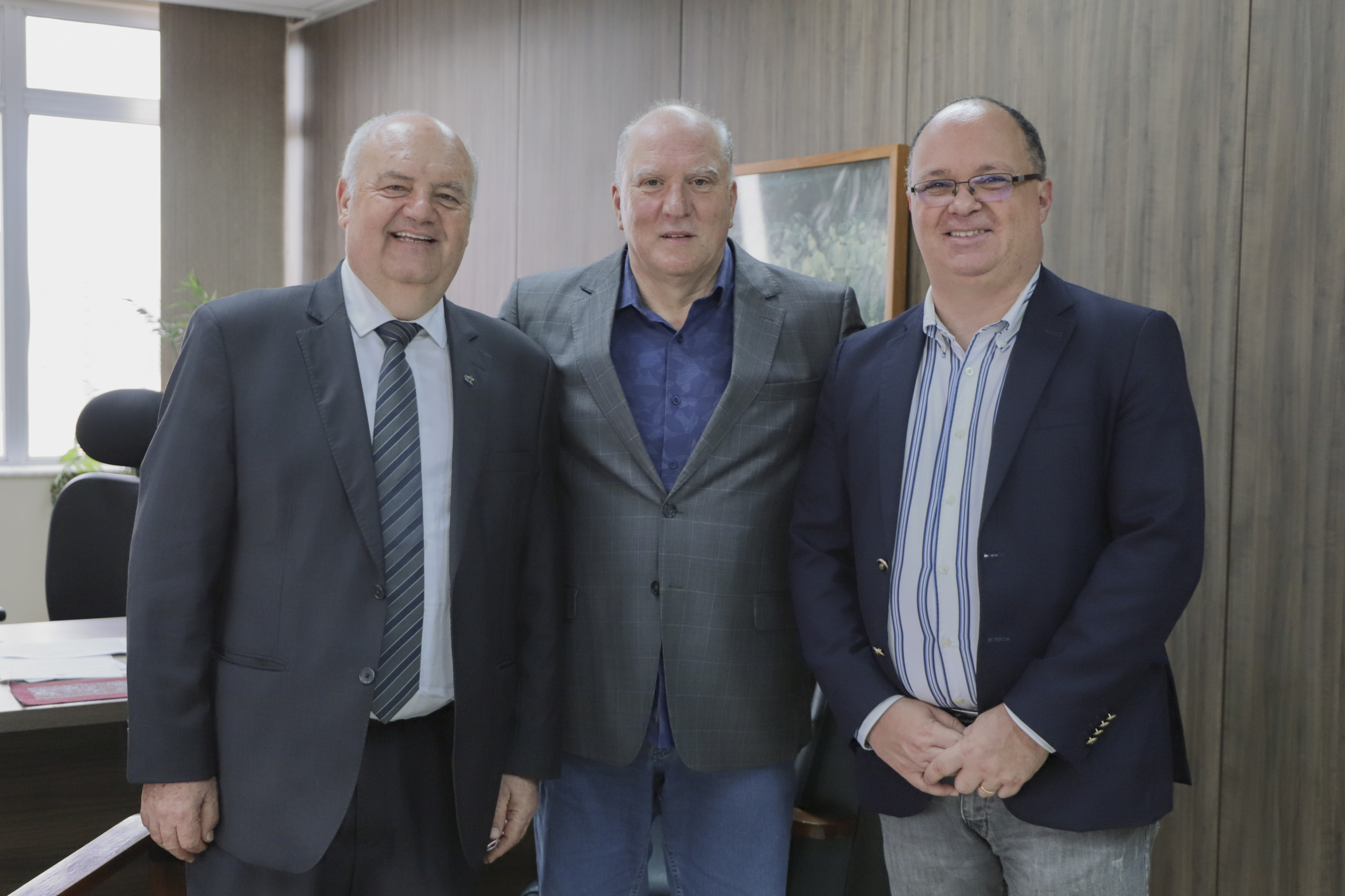 Luiz Colussi, Martins Costa e Jorge Araujo posam para a foto sorrindo. 