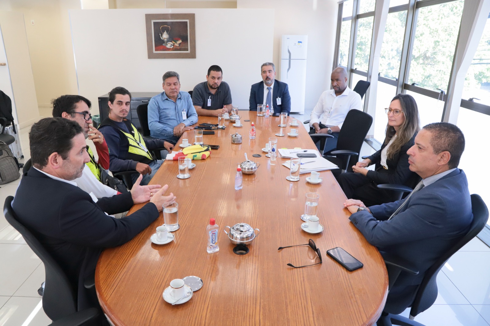 Foto da audiência, mostrando os participantes na mesa, dialogando.