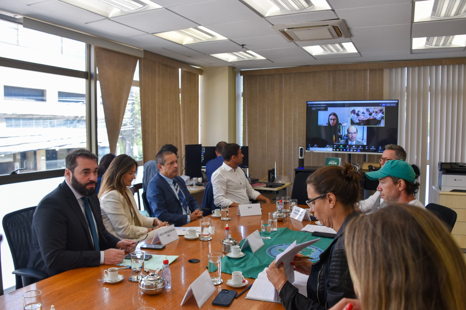 Foto mesa de negociação com ministro de fundo.