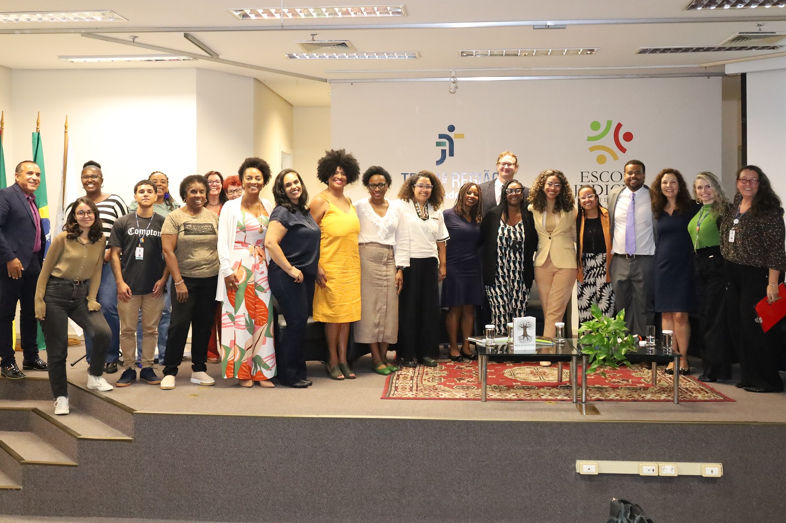 Foto posada de participantes do seminário, em pé, no palco.