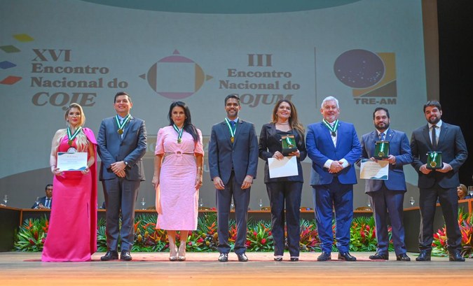 Foto de autoridades presentes no evento, recebendo medalhas