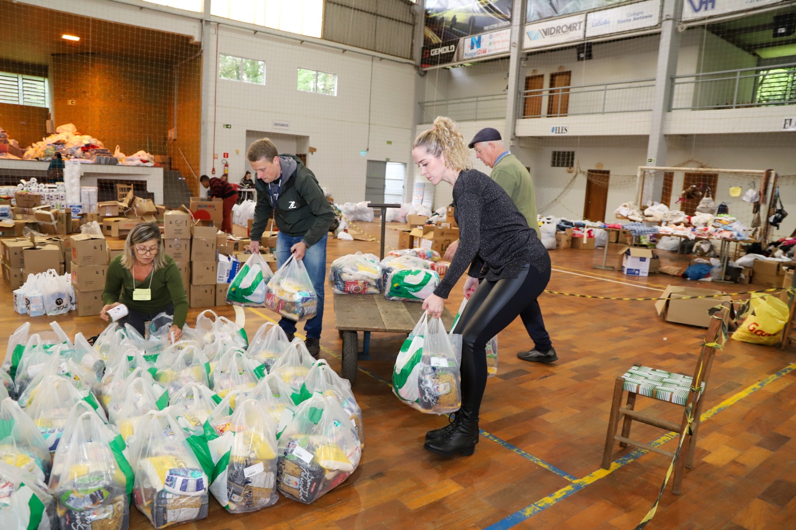 Foto dos voluntários separando as sacolas com os produtos doados