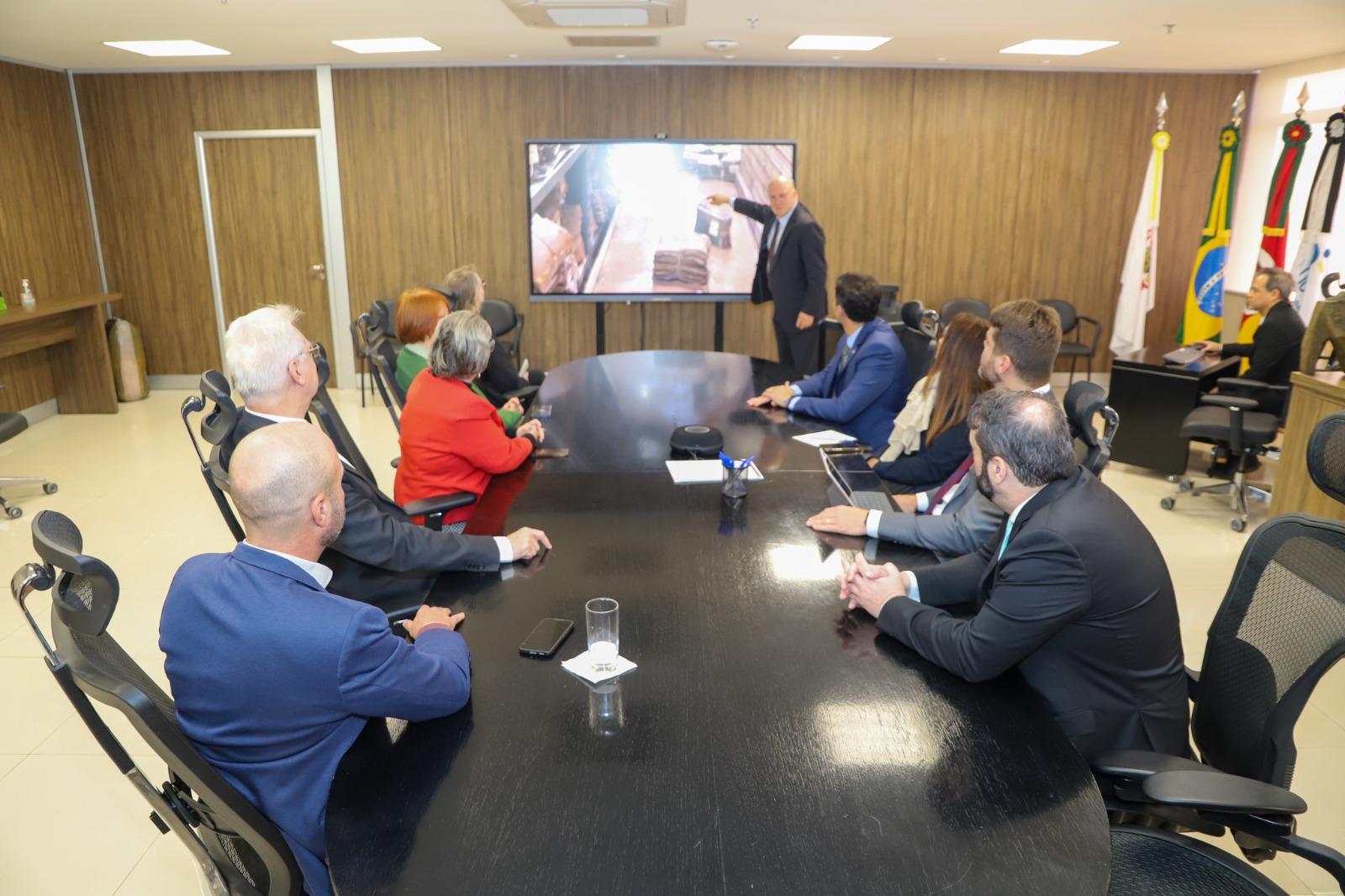 Foto presidente em pé mostrando plenário alagado pela TV.jfif