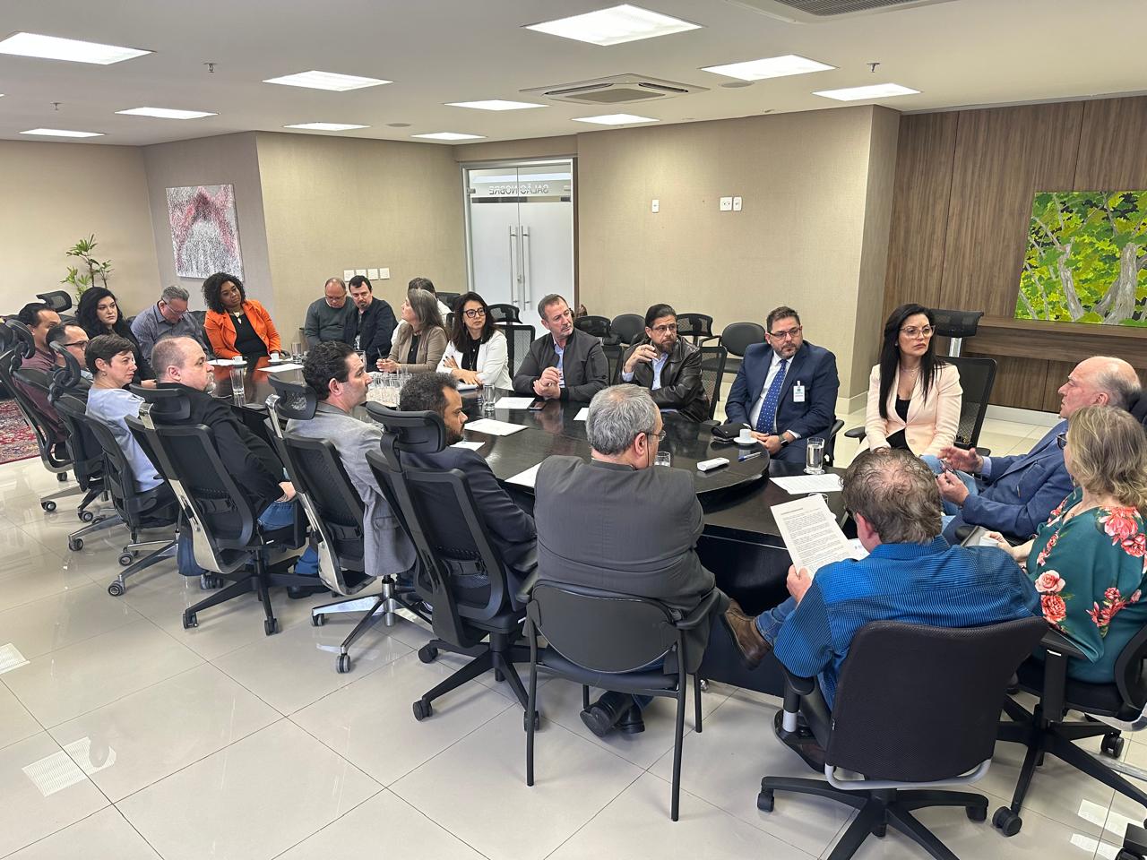 Foto da reunião no Salão Nobre, mostrando a mesa com todos os participantes