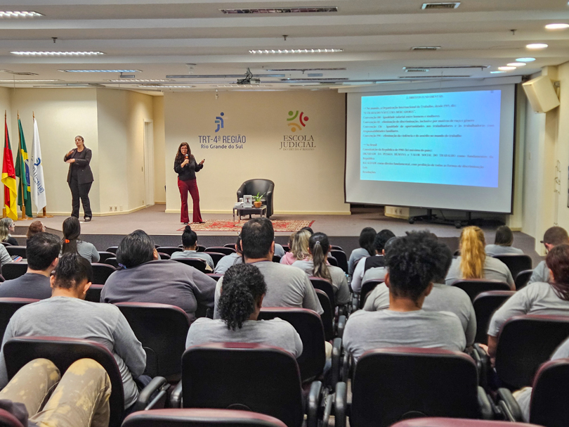 Foto da palestra, aparecendo público e palco.