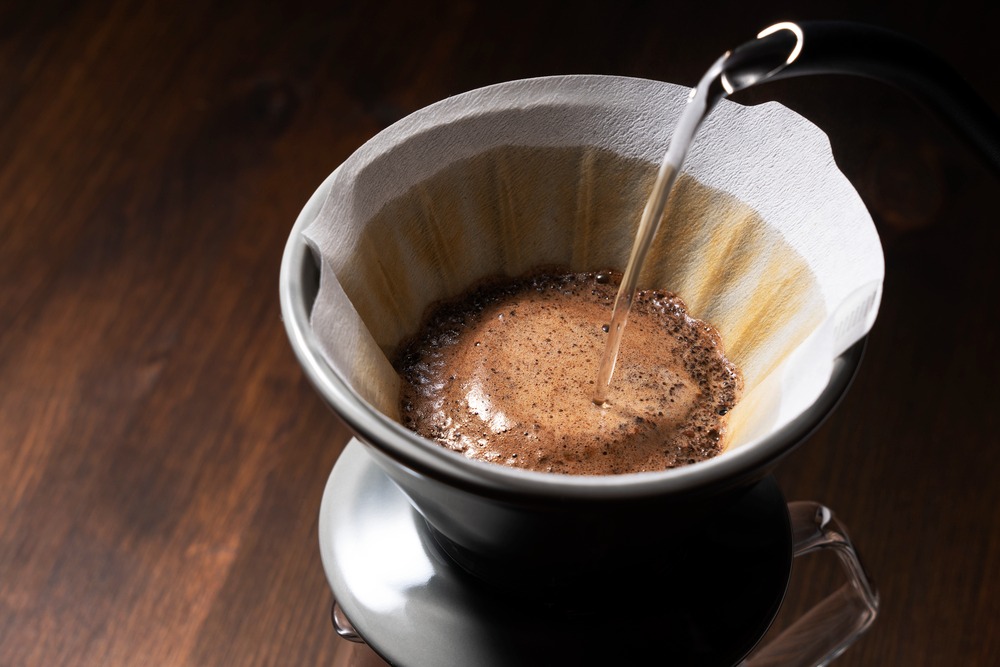Foto de um café sendo passado num coador com filtro de papel.