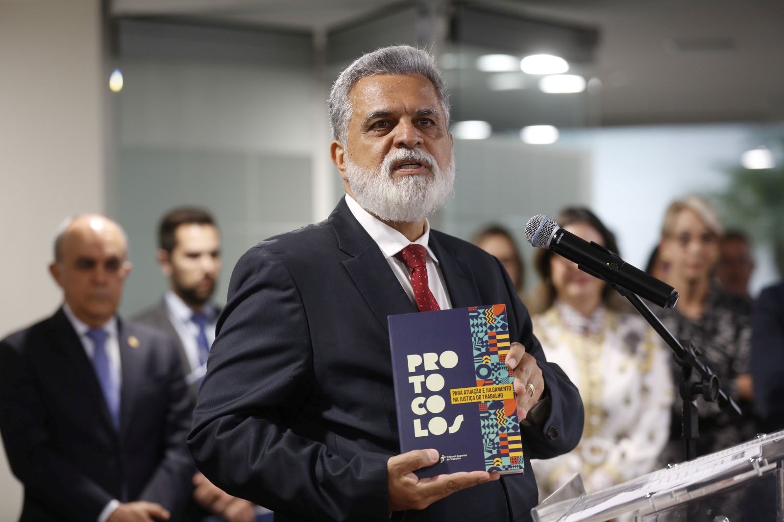 Ministro Lelio Bentes, segurando o livro do Protocolo