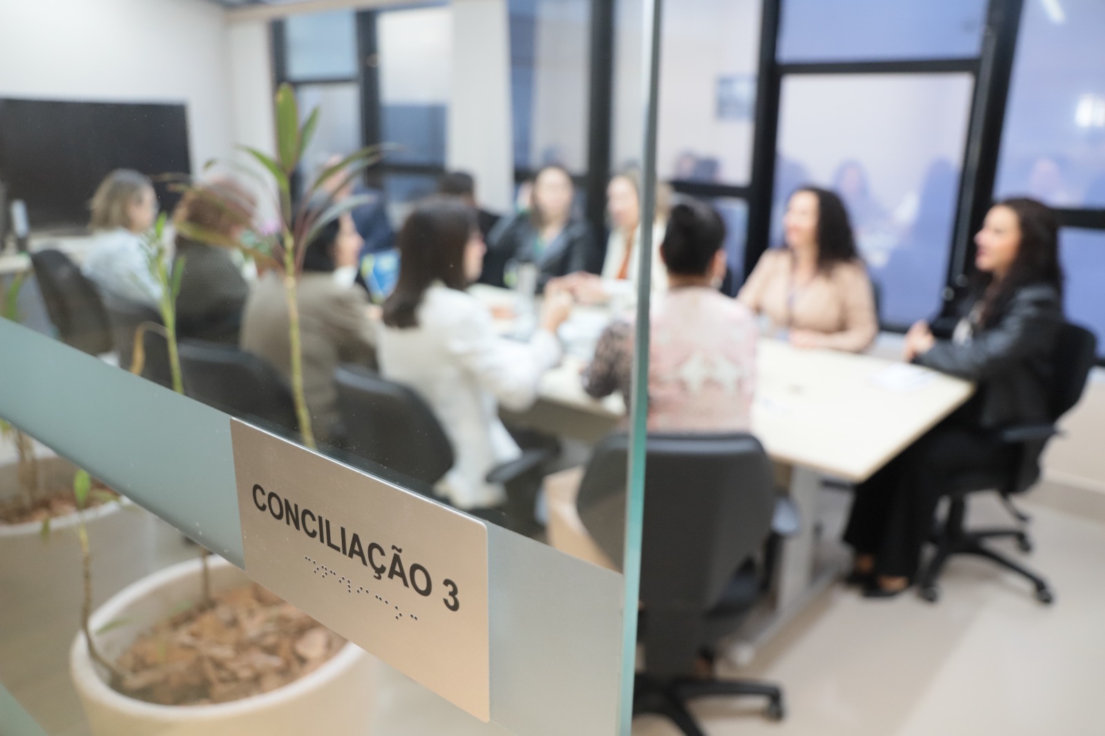 Foto da porta de vidro, com foco no letreiro "conciliação".