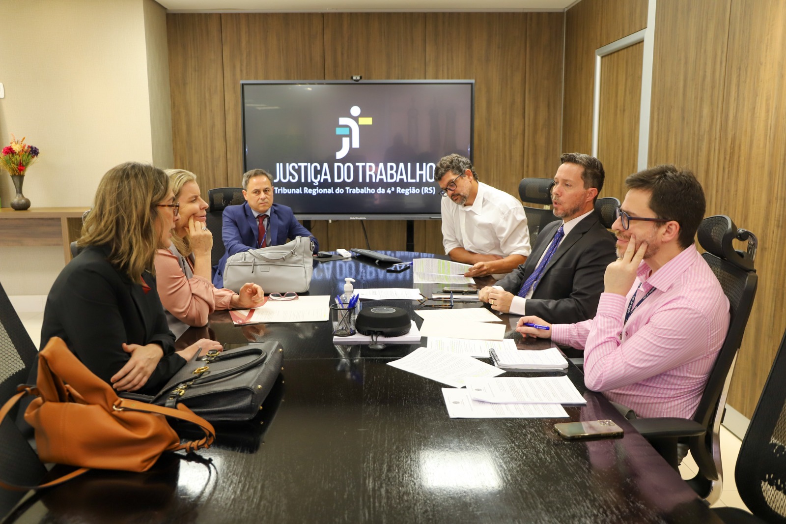 Imagem da mesa de reuniões com os participantes. São servidores, magistrados e procuradores do TRT-RS MPT-RS.