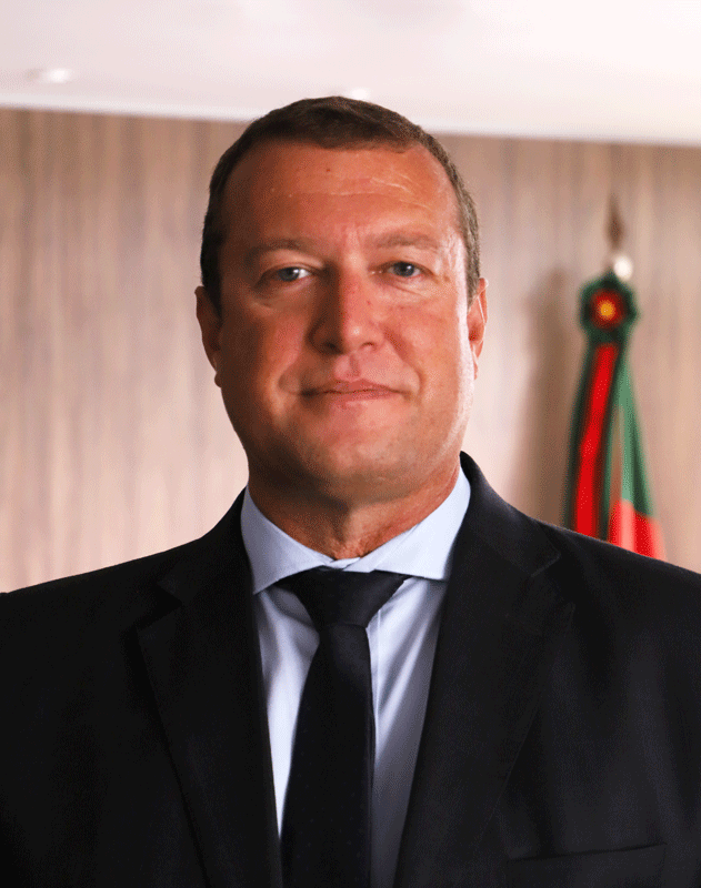 Retrato do servidor Eder Oliveira. Ele tem a pele e olhos claros. Seus cabelos são loiros e bem curtos. Veste terno e gravata pretos e camisa azul claro