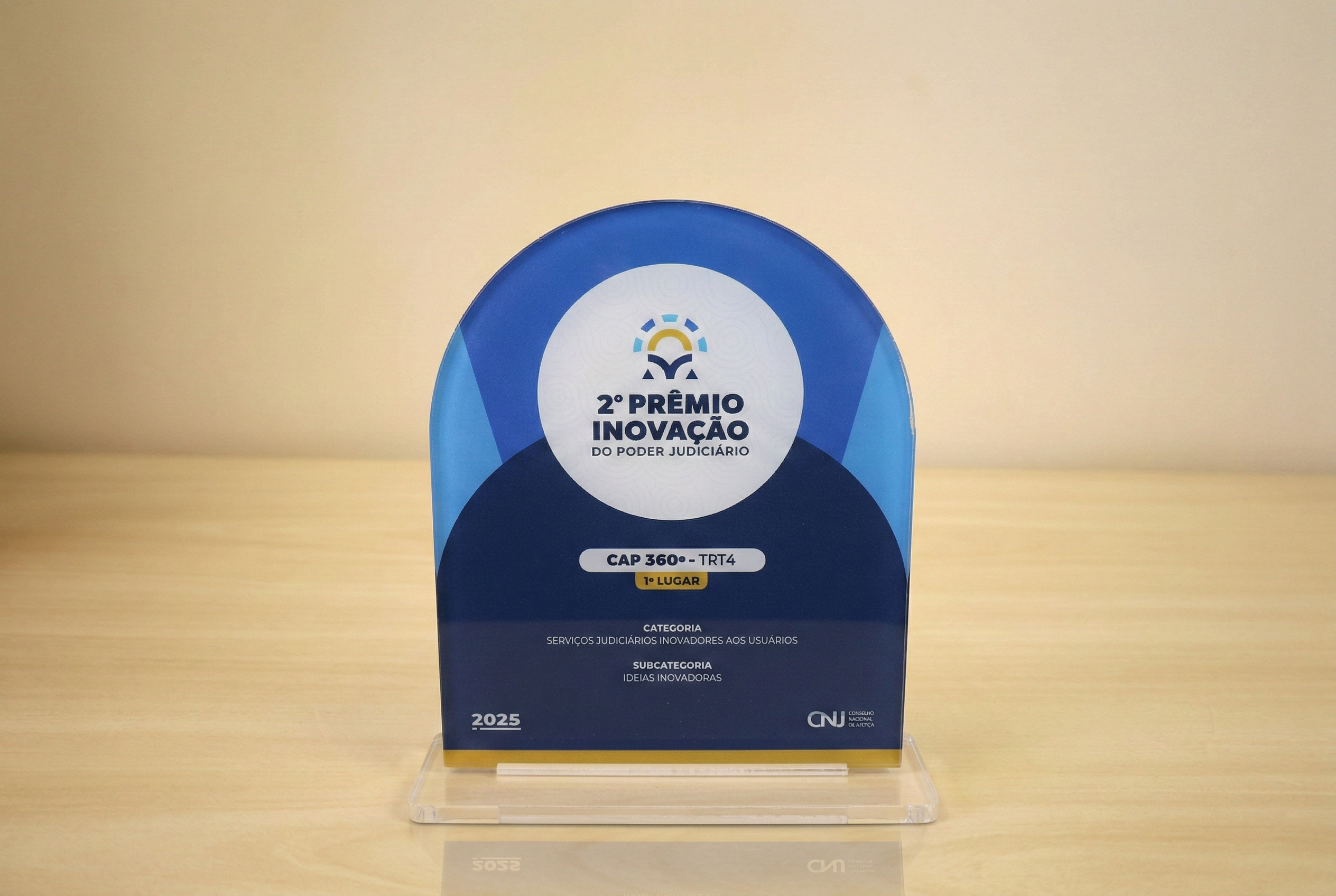 foto de troféu em acrílico em formato de retângulo com topo semicircular em tons azuis com o título do evento no meio