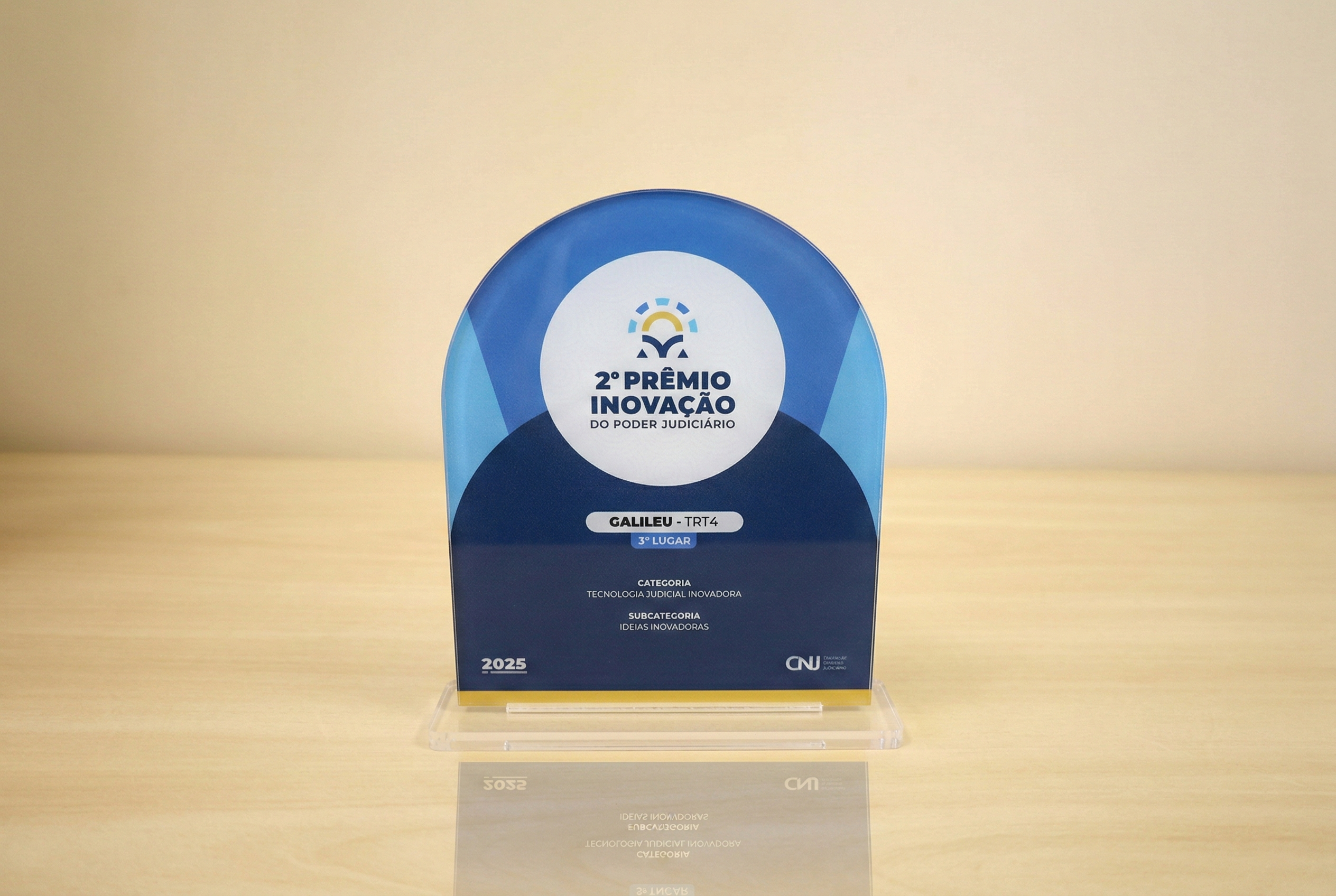 foto de troféu em acrílico em formato de retângulo com topo semicircular em tons azuis com o título do evento no meio